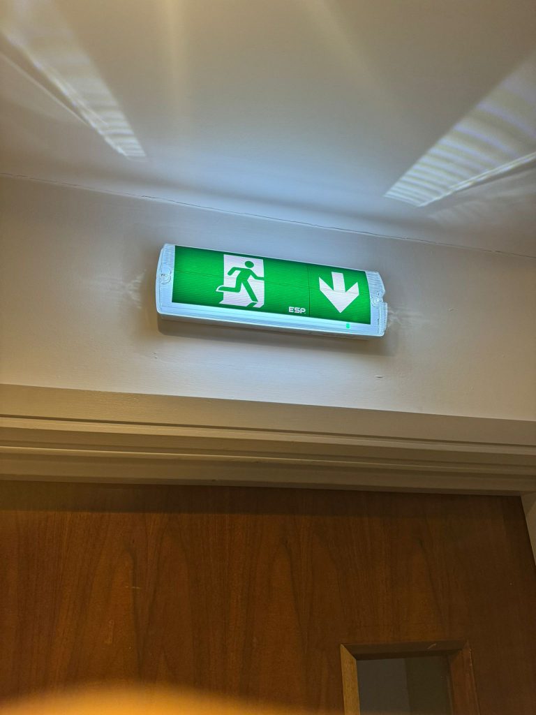 LED running man emergency exit sign installed above a doorway to clearly identify the emergency escape route.
