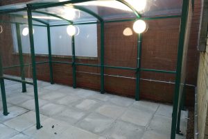 Commercial smoking shelter illuminated by new LED external lighting installation.